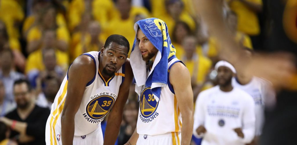 Kevin Durant et Stephen Curry discutent pendant un match des Warriors.