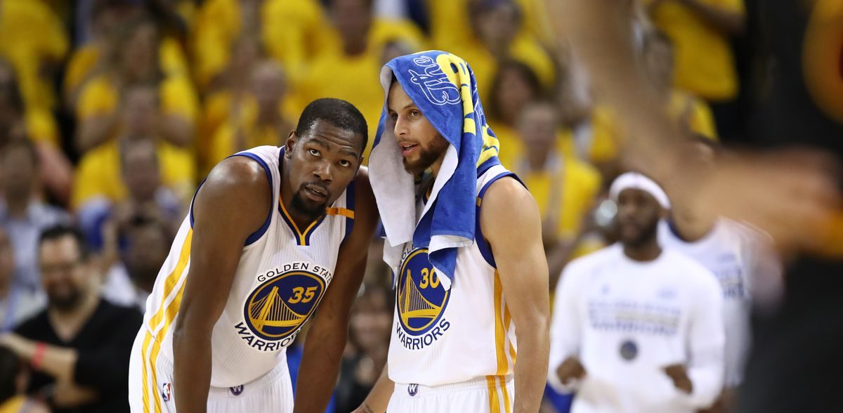 Kevin Durant et Stephen Curry discutent pendant un match des Warriors.