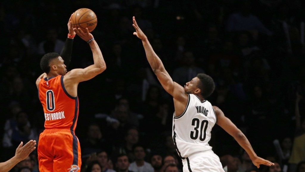 Russell Westbrook sous le maillot du Thunder, en plein shoot sur Thaddeus Young sous le maillot des Brooklyn Nets