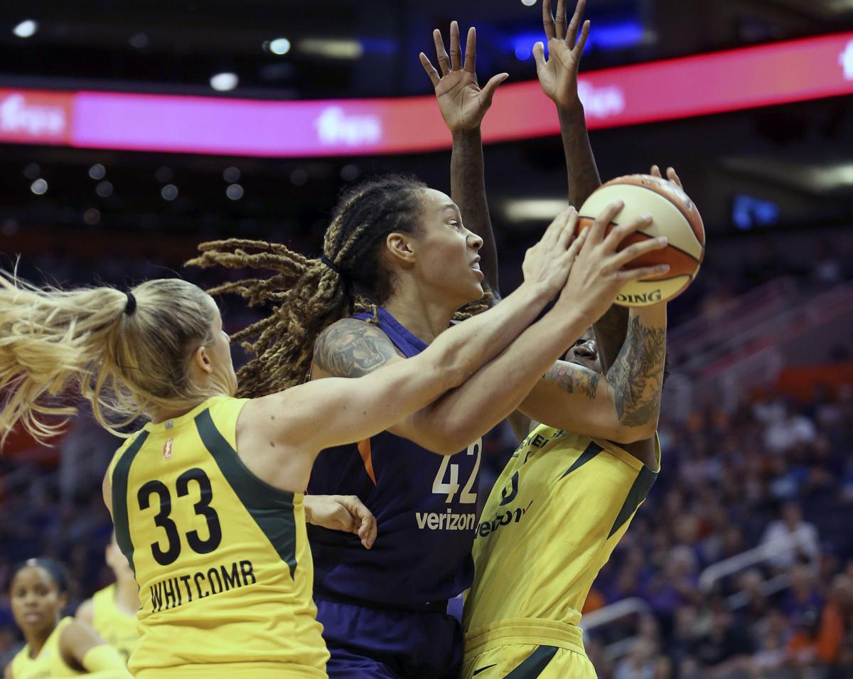 Brittney Griner, balle en main, à la lutte avec Sami Whitcomb et Natasha Howard.