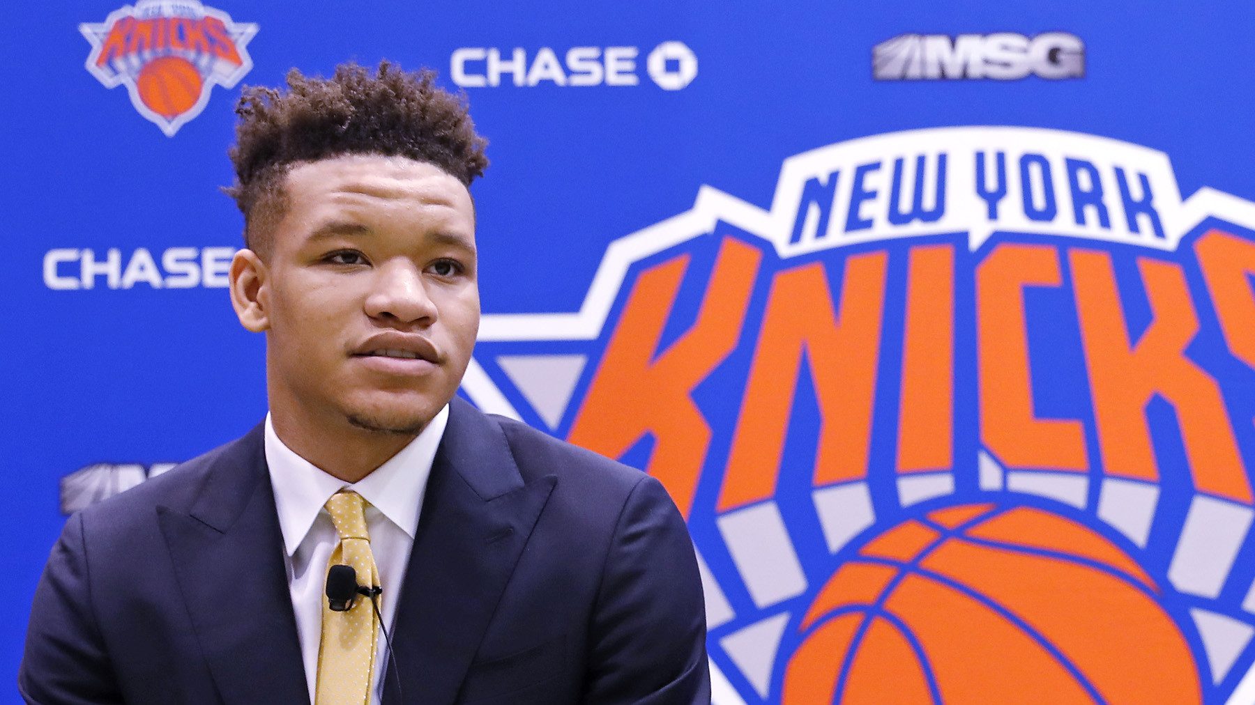 Kevin Knox en conférence de presse, devant le logo des Knicks de New York