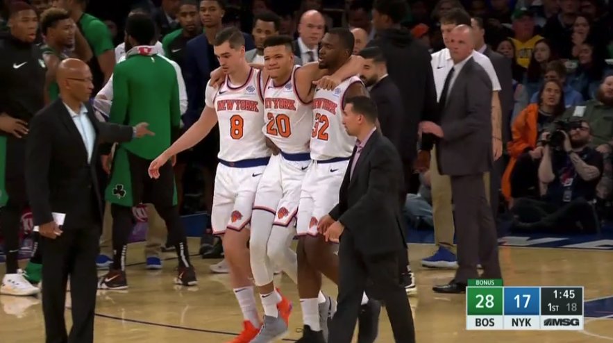 Kevin Knox est aidé par ses coéquipiers pour sortir du parquet après sa blessure.