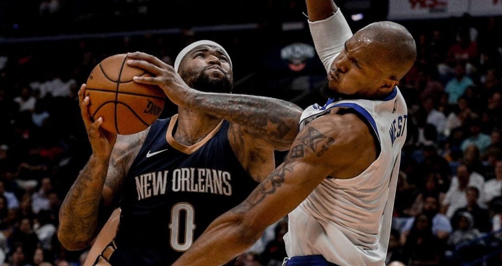 Demarcus Cousins, à gauche, lutte avec David West en NBA.