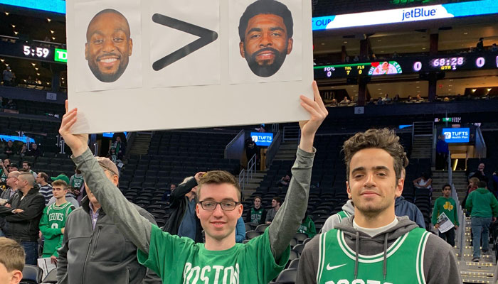 Les fans des Celtics avec un panneau comparant Kyrie Irving et Kemba Walker