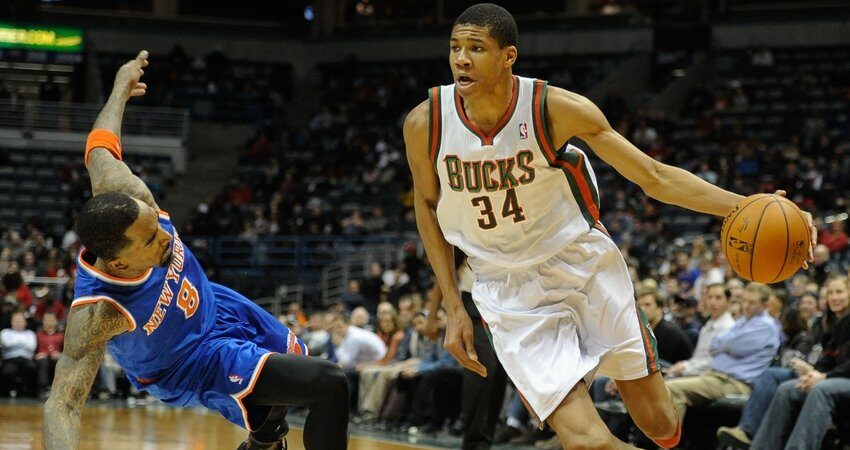 Giannis Antetokounmpo met JR Smith au sol
