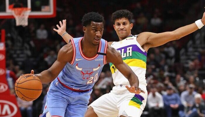 Adam Mokoka, ballon en main, dribble devant Frank Jackson lors du match opposant les Chicago Bulls aux New Orleans Pelicans