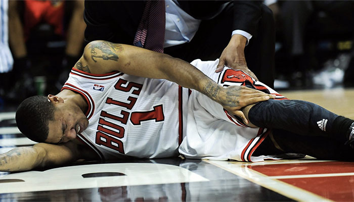 Derrick Rose, sous le maillot des Chicago Bulls, se tient le genou gauche dans un match face aux Sixers, le 28 avril, 2012