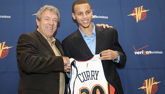 Stephen Curry et Larry Riley posant avec le maillot des Warriors lors de la Draft 2009