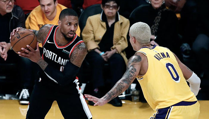 La superstar NBA Damian Lillard, ballon en main, face Kyle Kuzma lors d’un match entre les Portland Trail Blazers et les Los Angeles Lakers