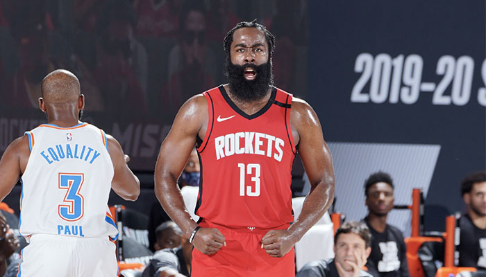 La superstar NBA James Harden montre les muscles devant Chris Paul lors d’un match de playoffs entre les Houston Rockets et le Oklahoma City Thunder