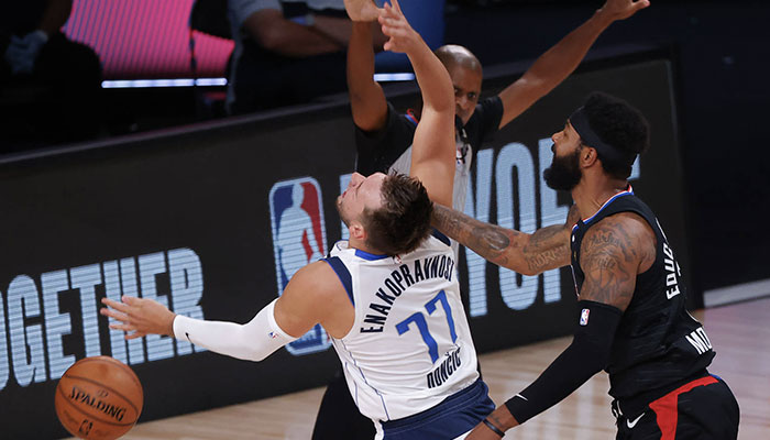 La star NBA des Dallas Mavericks Luka Doncic subit une faute grossière de la part de son adversaire des Los Angeles Clippers Marcus Morris lors du Game 6 du premier tour des playoffs