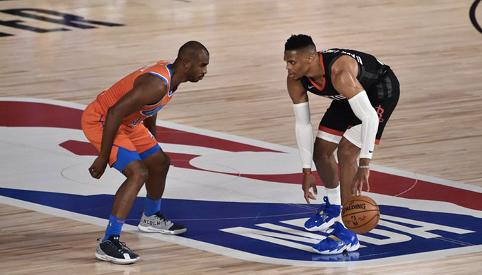 La superstar NBA des Houston Rockets Russell Westbrook ballon en main face au vétéran du Thunder d’Oklahoma City Chris Paul