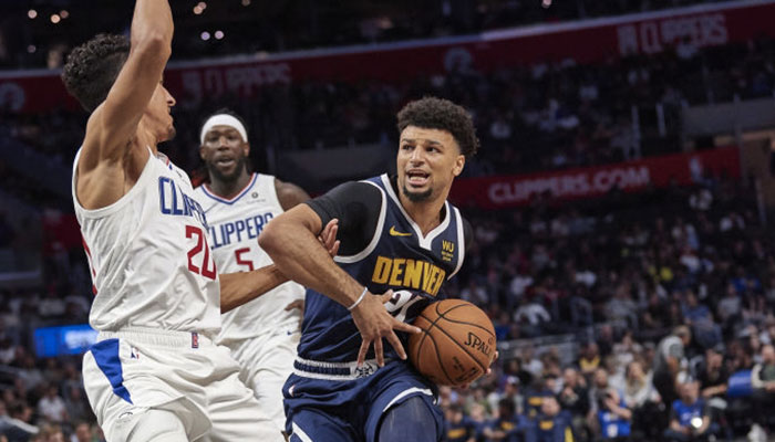La star NBA des Denver Nuggets Jamal Murray en difficulté balle en mains face aux joueurs des Los Angeles Clippers Landry Shamet et Montrezl Harrell
