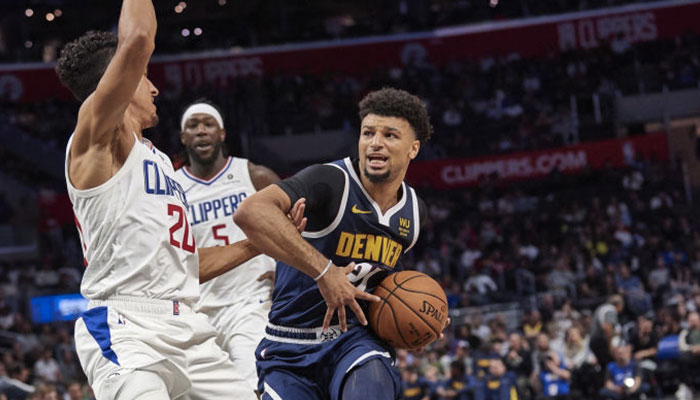 La star NBA des Denver Nuggets Jamal Murray en difficulté balle en mains face aux joueurs des Los Angeles Clippers Landry Shamet et Montrezl Harrell