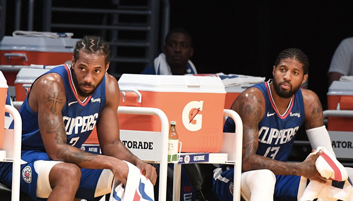 Les stars des Los Angeles Clippers, Kawhi Leonard (gauche) et Paul George (droite), sur le banc de leur équipe lors d’un match de pré-saison NBA face aux Los Angeles Lakers