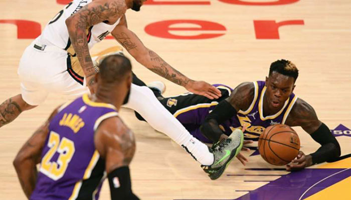 Dennis Schroder à la lutte avec le maillot des Lakers devant Lebron James