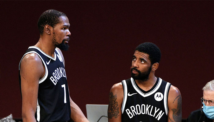 Les deux superstars NBA des Brooklyn Nets, Kevin Durant et Kyrie Irving, en pleine discussion sur la table de marque lors d’un match face aux Atlanta Hawks