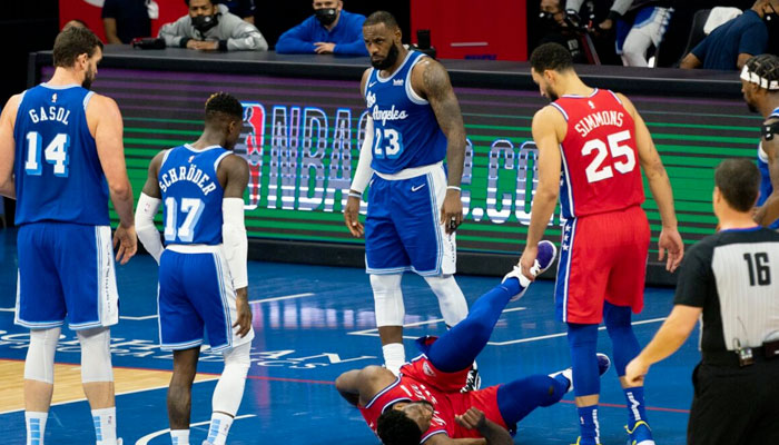 LeBron James regarde Joel Embiid au sol