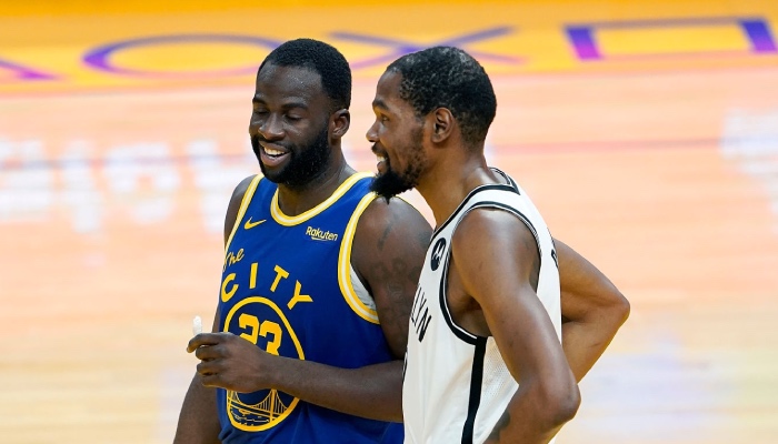 L'intérieur star des Golden State Warriors, Draymond Green, discute avec son ancien coéquipier Kevin Durant lors d'un match face aux Brooklyn Nets