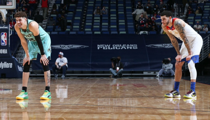 Les deux frères Ball, Lamelo, tout sourire, et Lonzo, mains sur les genoux lors d'un match entre les Charlotte Hornets et les New Orleans Pelicans