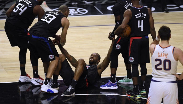 La superstar NBA des Los Angeles Clippers, Kawhi Leonard, au sol et relevée par ses coéquipiers lors d'un match face aux Phoenix Suns