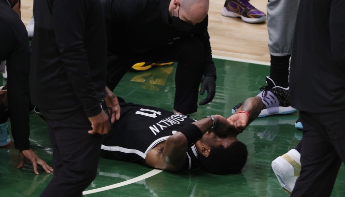 La superstar NBA des Brooklyn Nets, Kyrie Irving, allongé sur le parquet des Milwaukee Bucks après s'être tordu la cheville lors du Game 4 des demi-finales de conférence Est