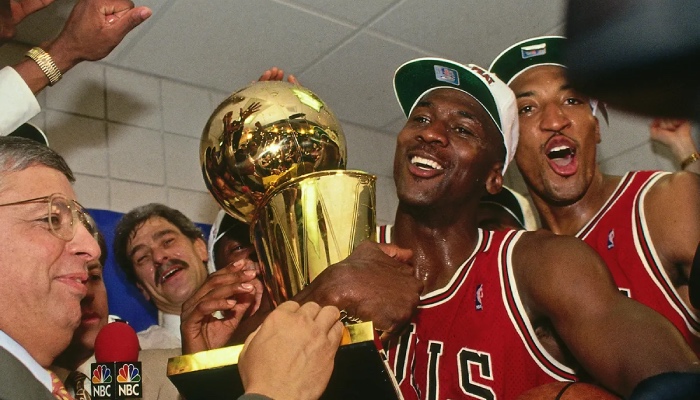 La légende NBA des Chicago Bulls, Michael Jordan, porte le trophée Larry O'Brien devant les yeux de Jerry Krause, Phil Jackson et Scottie Pippen